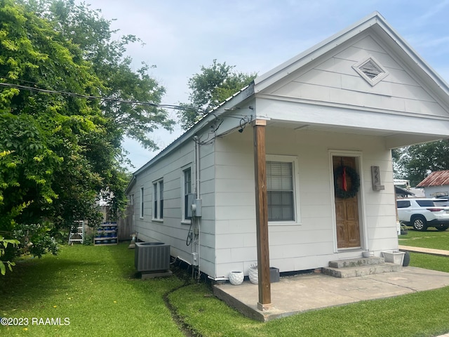 exterior space with central AC unit and a front yard