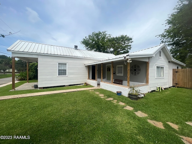 rear view of property with a yard, a carport, and a porch