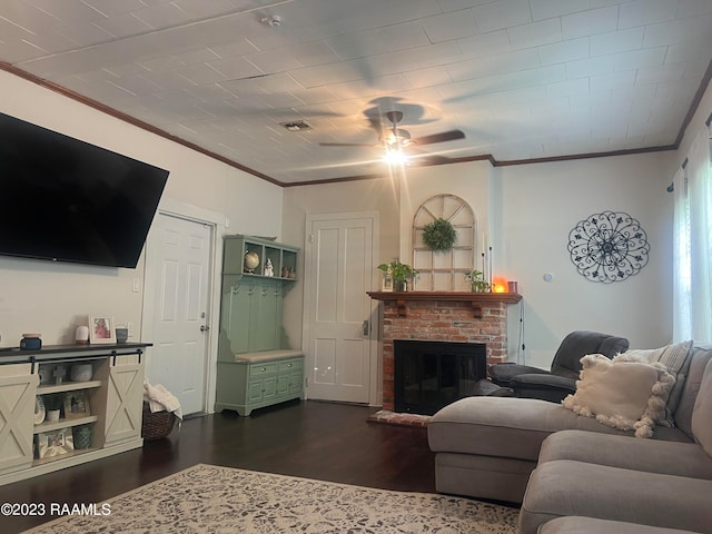 living room with ornamental molding, dark wood-type flooring, a brick fireplace, and ceiling fan