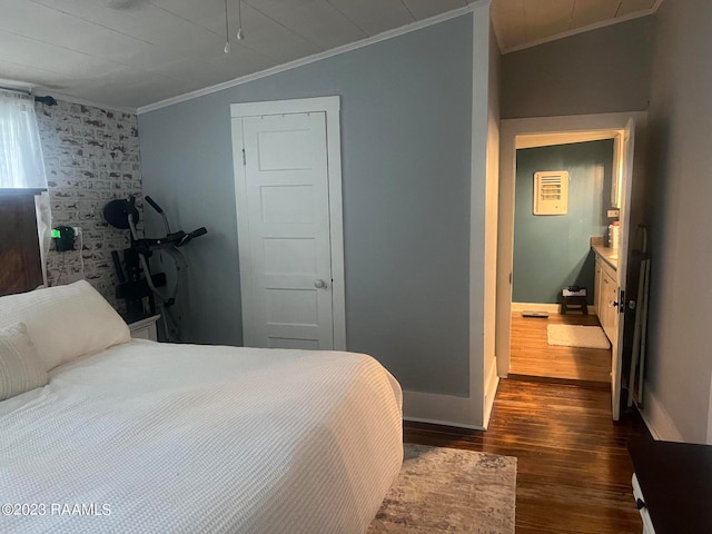 bedroom featuring ornamental molding, brick wall, dark hardwood / wood-style floors, and vaulted ceiling