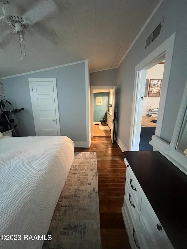 bedroom with ornamental molding, dark wood-type flooring, ceiling fan, and vaulted ceiling