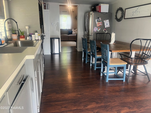 dining area with ornamental molding, dark hardwood / wood-style floors, and sink