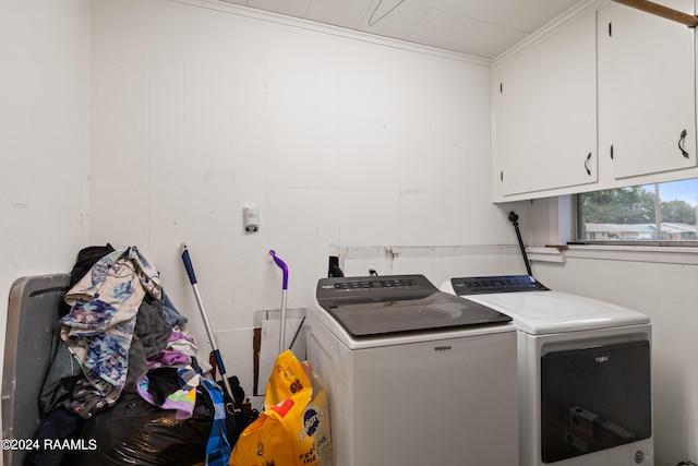 laundry room featuring cabinets, crown molding, and washing machine and dryer