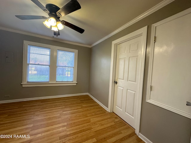 empty room with ceiling fan, light wood-type flooring, and ornamental molding