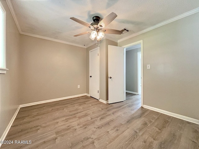 spare room featuring wood-type flooring, ceiling fan, crown molding, and a textured ceiling