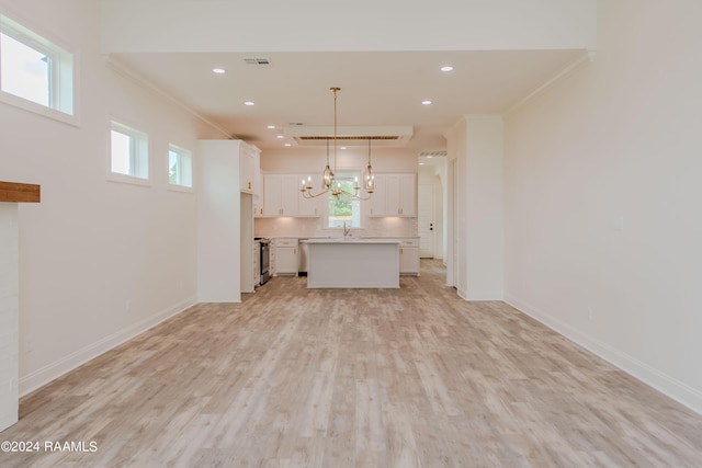 kitchen with white cabinets, pendant lighting, a center island, and ornamental molding