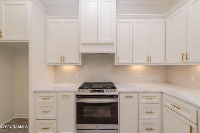 kitchen featuring white cabinets, backsplash, light stone counters, and stainless steel gas range oven