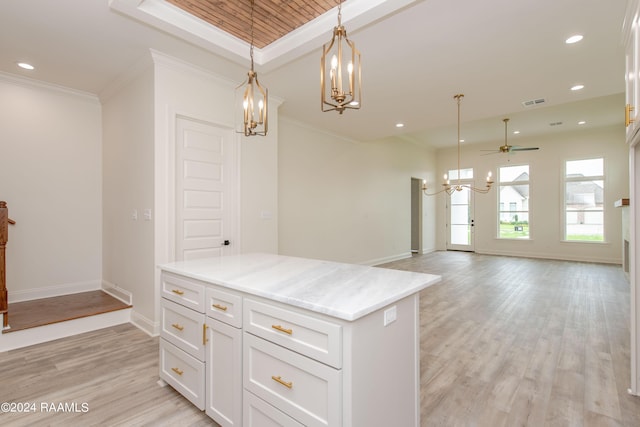 kitchen with light hardwood / wood-style floors, hanging light fixtures, ceiling fan, ornamental molding, and white cabinetry