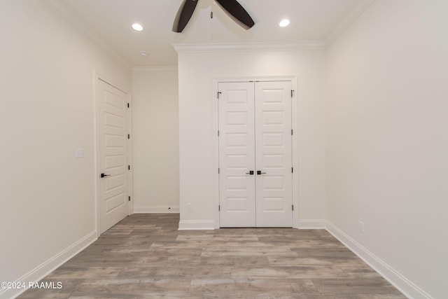 unfurnished bedroom with ceiling fan, crown molding, a closet, and light hardwood / wood-style flooring