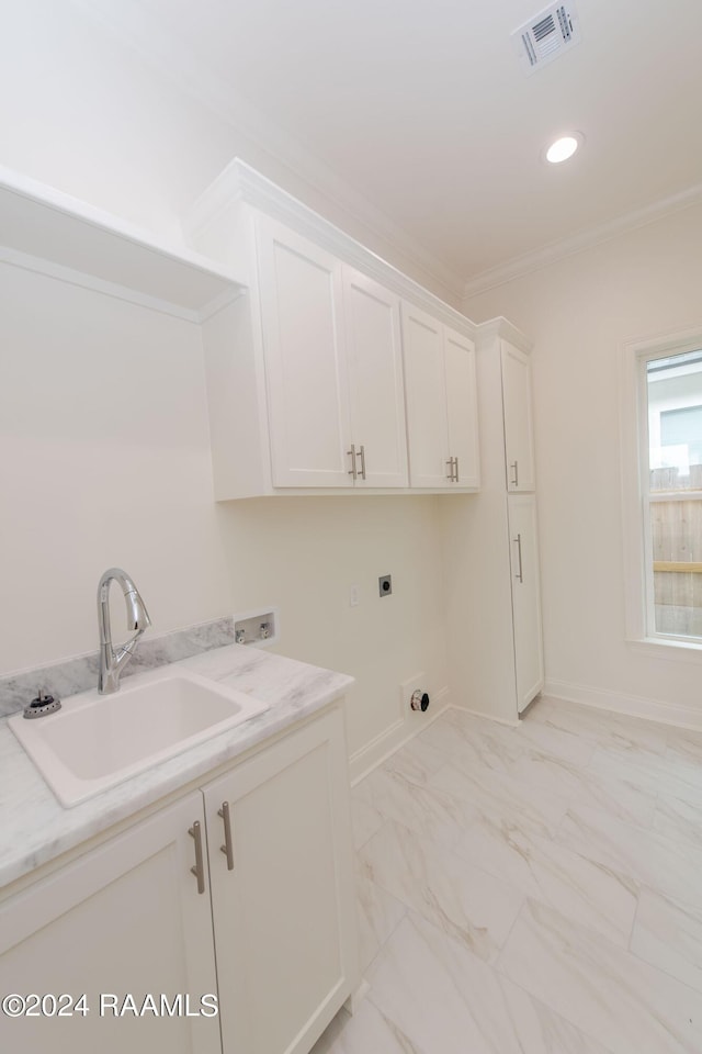 laundry room featuring electric dryer hookup, cabinets, ornamental molding, and sink