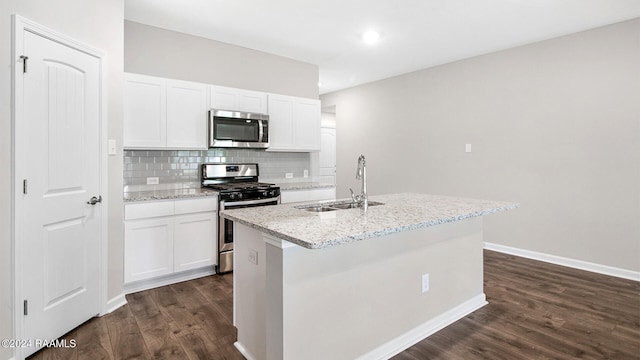 kitchen featuring white cabinets, a center island with sink, sink, and appliances with stainless steel finishes