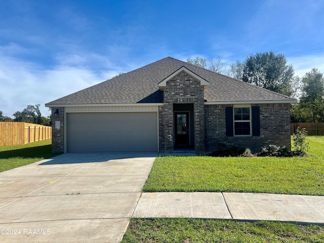 view of front of property featuring a front yard and a garage