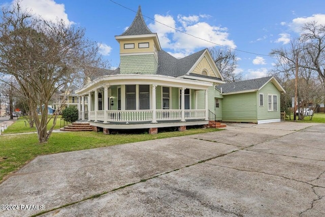 victorian-style house featuring a front lawn and covered porch