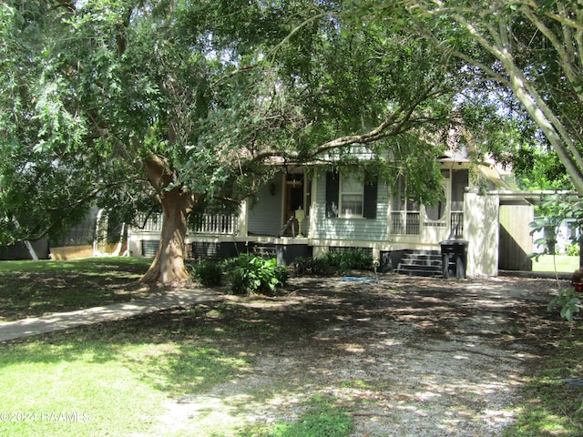 view of property hidden behind natural elements featuring a porch