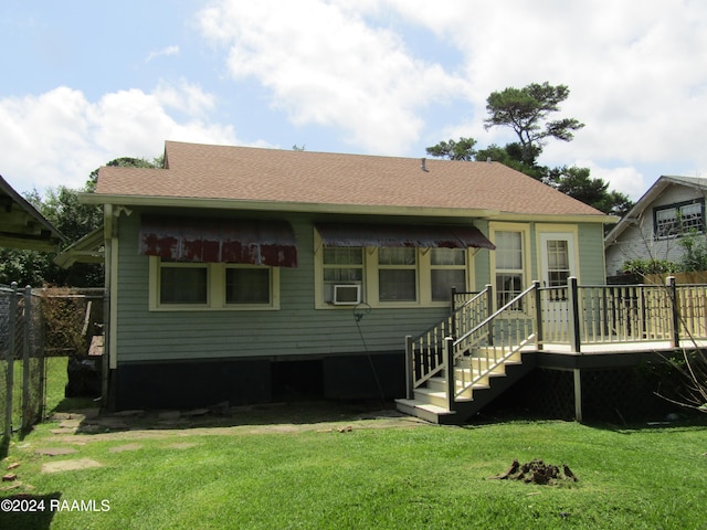 back of property with a deck, cooling unit, and a lawn