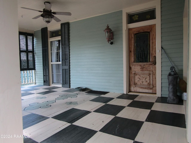 view of exterior entry with a porch and ceiling fan