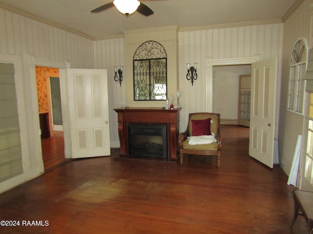 living area featuring ceiling fan, dark hardwood / wood-style floors, and crown molding