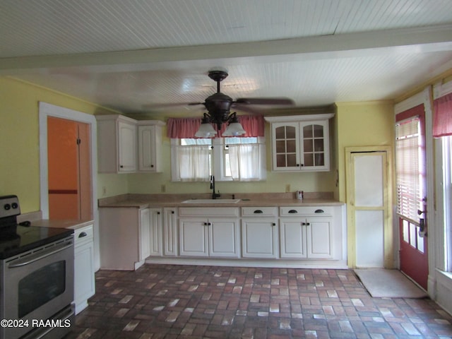 kitchen featuring beam ceiling, sink, white cabinets, and stainless steel range with electric stovetop