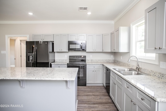 kitchen featuring black appliances, sink, a kitchen breakfast bar, and crown molding