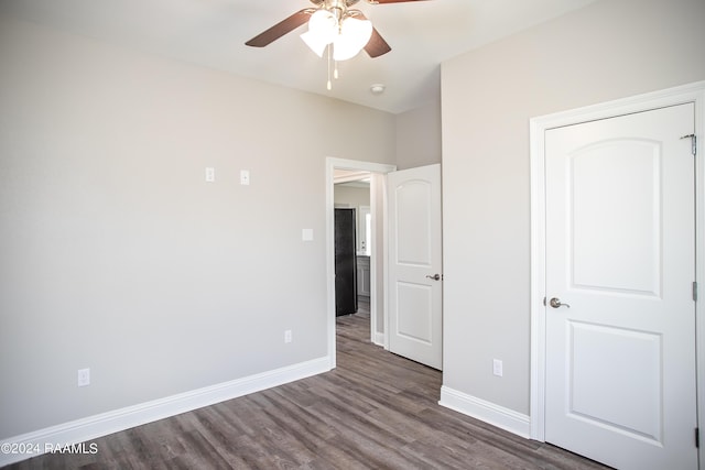 unfurnished bedroom featuring ceiling fan and dark hardwood / wood-style flooring