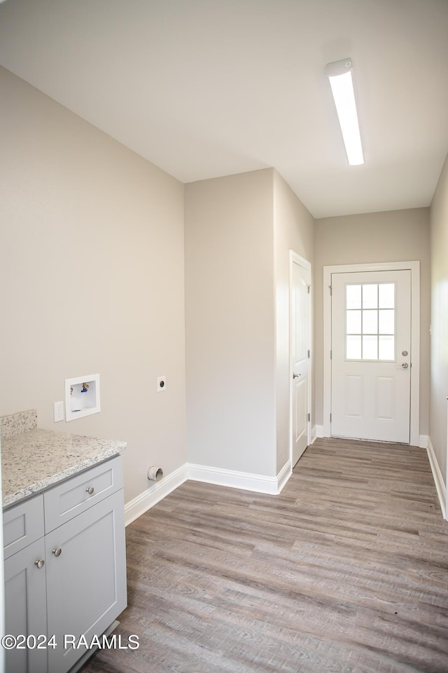 laundry area featuring cabinets, washer hookup, electric dryer hookup, and light hardwood / wood-style flooring