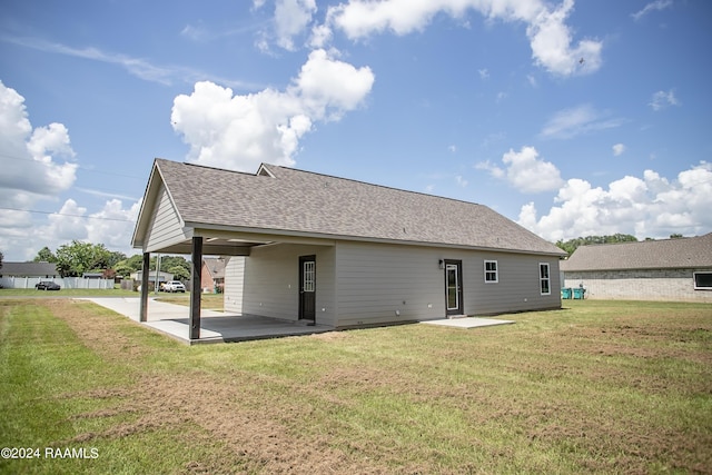 back of house with a lawn and a patio