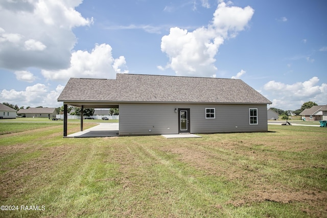 rear view of house featuring a lawn and a patio