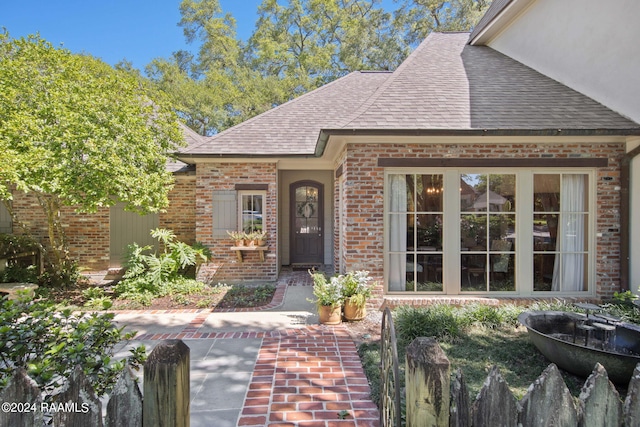 property entrance with brick siding and roof with shingles