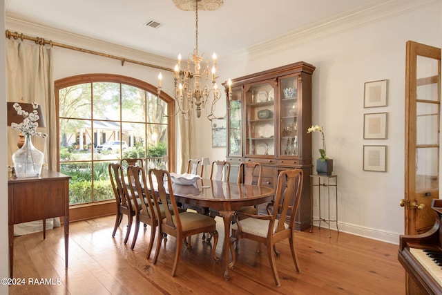 dining room featuring a chandelier, light hardwood / wood-style floors, a healthy amount of sunlight, and crown molding