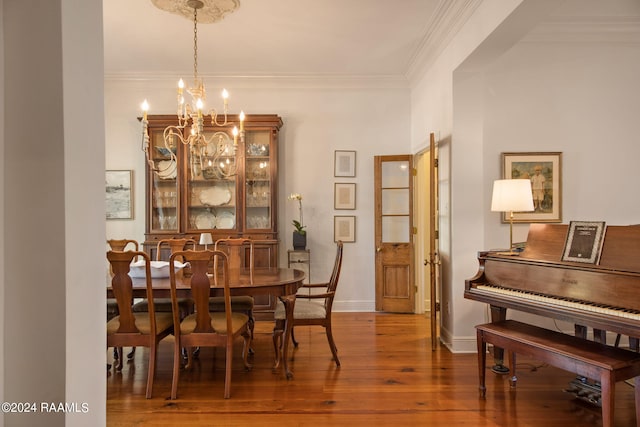 dining space featuring wood-type flooring, a chandelier, and crown molding