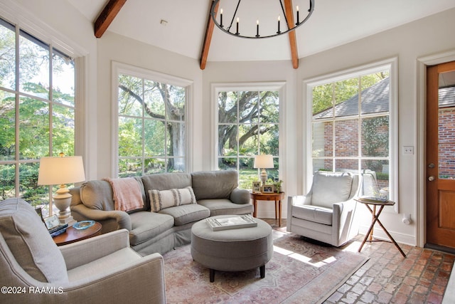 sunroom with plenty of natural light, lofted ceiling with beams, and a chandelier