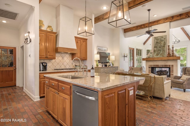 kitchen with stainless steel dishwasher, beamed ceiling, an island with sink, ceiling fan, and custom exhaust hood