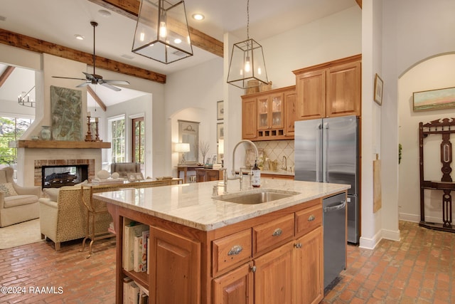 kitchen featuring a fireplace, ceiling fan, tasteful backsplash, beamed ceiling, and sink