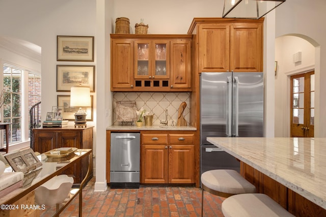 kitchen featuring light stone counters, tasteful backsplash, and appliances with stainless steel finishes