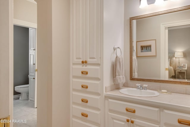 bathroom with tile flooring, toilet, and large vanity