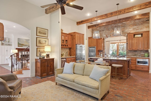 living room featuring beamed ceiling and ceiling fan