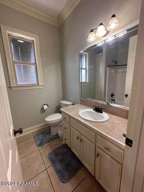 full bathroom with washtub / shower combination, tile patterned flooring, crown molding, toilet, and vanity