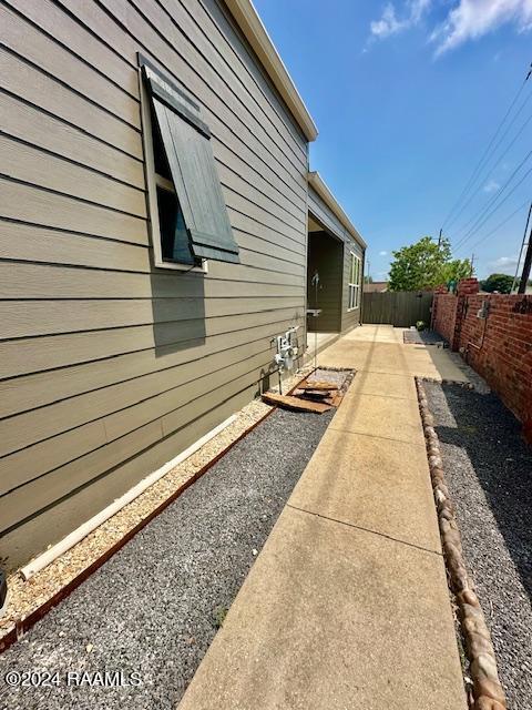 view of side of property featuring a patio and a fenced backyard