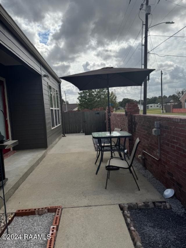 view of patio featuring fence and outdoor dining area