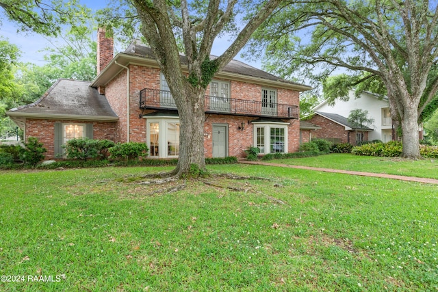 view of front of property with a balcony and a front yard