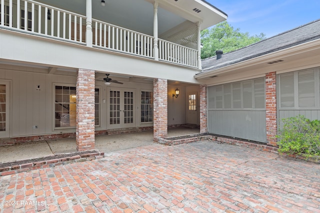 view of exterior entry featuring a patio area, ceiling fan, and a balcony