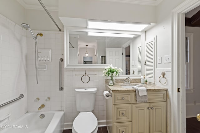 full bathroom featuring tile walls, toilet, tiled shower / bath combo, vanity, and ornamental molding