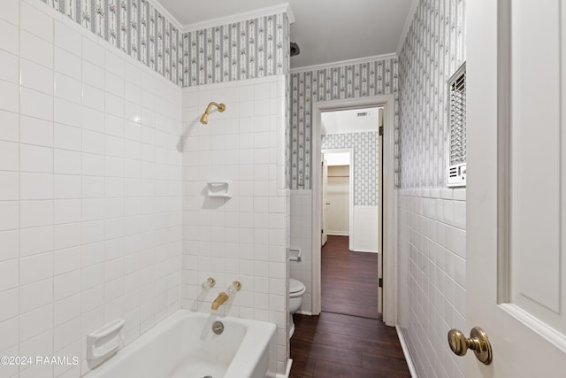 bathroom featuring tiled shower / bath, tile walls, hardwood / wood-style floors, toilet, and ornamental molding