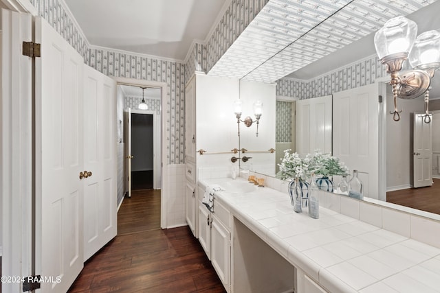 bathroom with hardwood / wood-style flooring, ornamental molding, and vanity