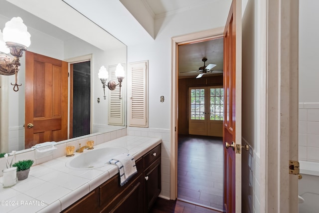 bathroom featuring wood-type flooring, oversized vanity, crown molding, and ceiling fan