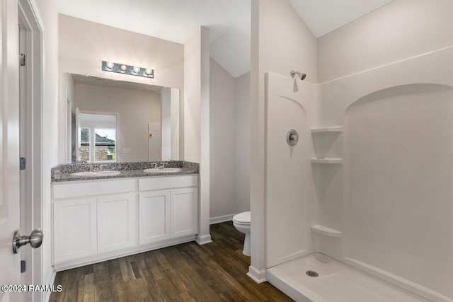 bathroom featuring vanity, a shower, wood-type flooring, toilet, and lofted ceiling