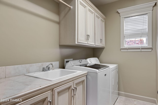 washroom featuring cabinets, independent washer and dryer, light tile patterned floors, and sink