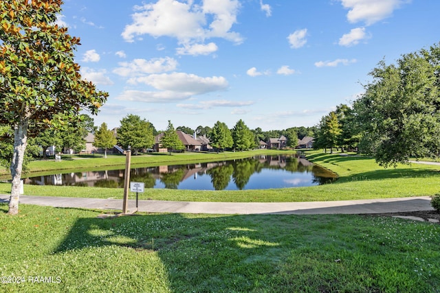 view of property's community featuring a lawn and a water view