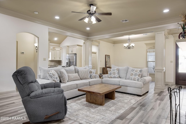 living room with decorative columns, crown molding, lofted ceiling, ceiling fan with notable chandelier, and light wood-type flooring