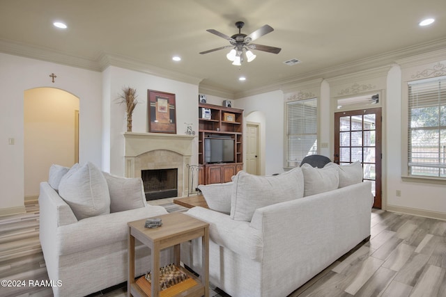 living room with ceiling fan, light hardwood / wood-style floors, and ornamental molding